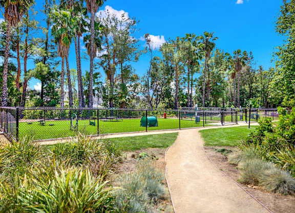 a path leading to a park with a playground and trees at Monterra Ridge Apartments,California