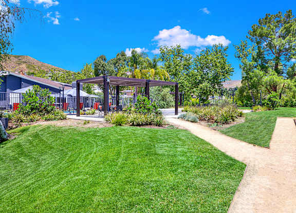 a path leading to a yard with a pergola at Monterra Ridge Apartments, Canyon Country ,91351