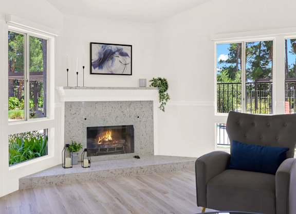 a living room with a fireplace and a chair at Monterra Ridge Apartments, California,91351