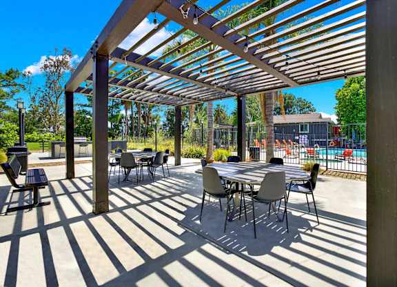 a patio with tables and chairs under awning at Monterra Ridge Apartments,California