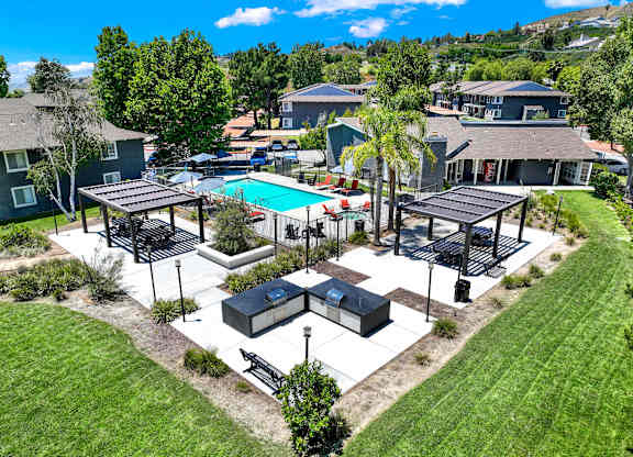 an aerial view of a backyard with a pool and picnic tables at Monterra Ridge Apartments, Canyon Country ,91351