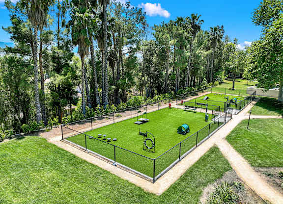 a tennis court in a park with trees at Monterra Ridge Apartments,California