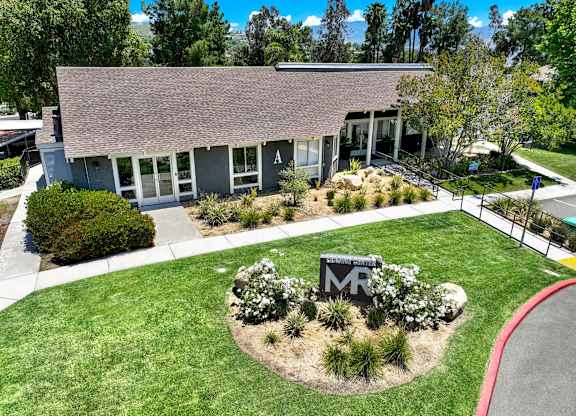the front of a building with a lawn and a sign in front of it at Monterra Ridge Apartments, Canyon Country, California