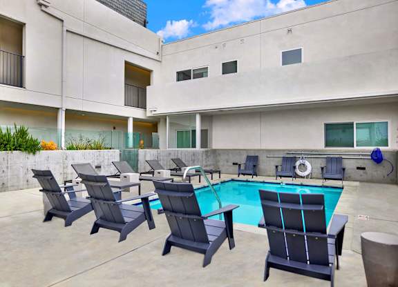 the pool area of a building with chairs and a swimming pool at the perch, Los Angeles, CA