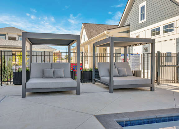 Two grey couches are placed on a patio.