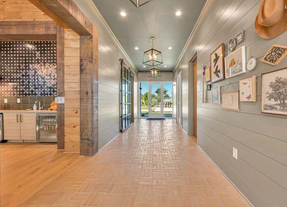 A long hallway with a tile floor and pictures on the wall.