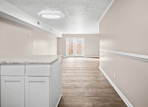 A kitchen with white cabinets and a marble countertop.