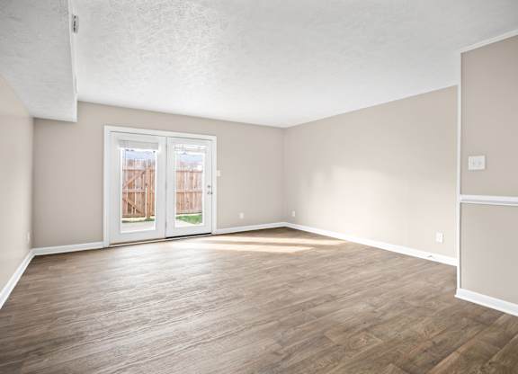 Empty room with wooden floors and white walls.