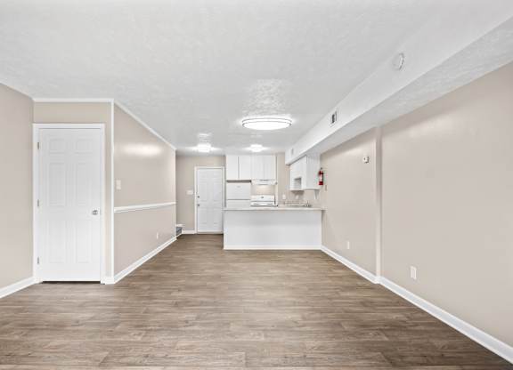 A large empty room with wooden floors and white walls.