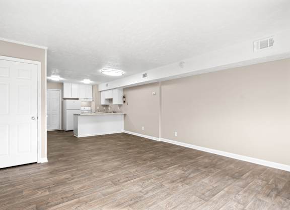 A room with wooden flooring and white walls.