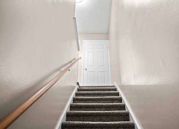 A staircase with a white door at the top.