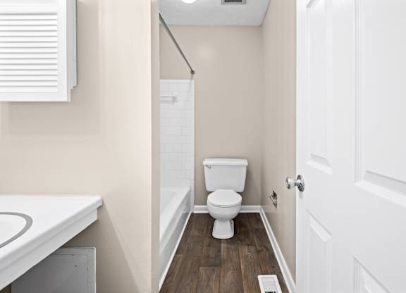 A white toilet in a small bathroom with a white door.