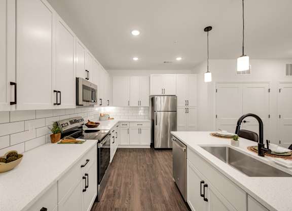 A modern kitchen with white cabinets and a stainless steel refrigerator.