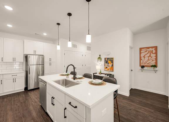 A modern kitchen with white cabinets and a stainless steel refrigerator.