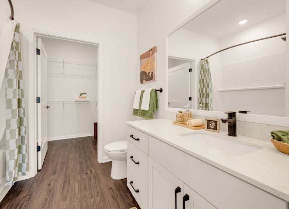 A bathroom with a toilet, sink, and shower.