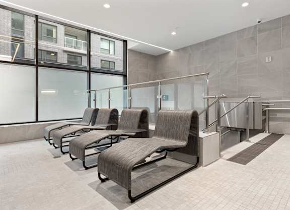 A row of grey chairs by an indoor pool at Skye rentals in Ottawa