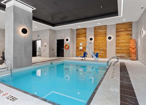A large indoor swimming pool with a diving board.
