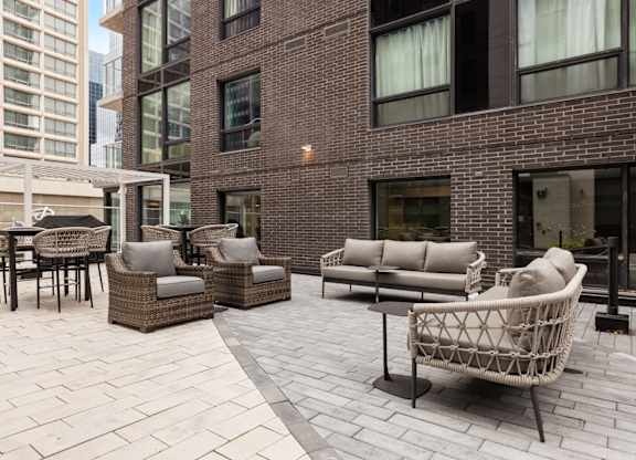 A patio with a wicker chair and table.