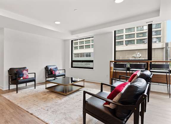 A living room with a black leather chair and a glass coffee table.