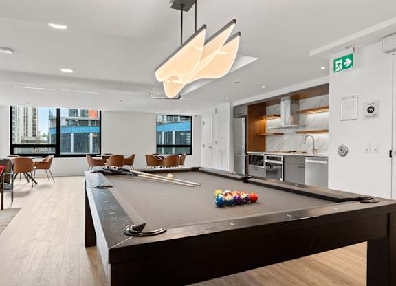A pool table in a room with a view of the city.