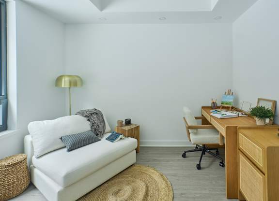 a living room with a couch and a desk