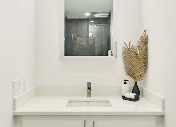 a white bathroom with a sink and a mirror