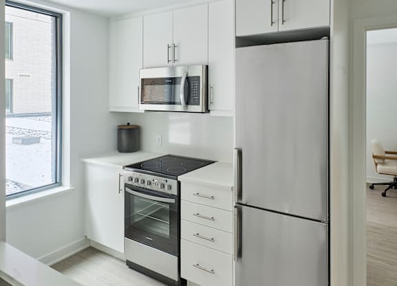 a kitchen with white cabinets and stainless steel appliances
