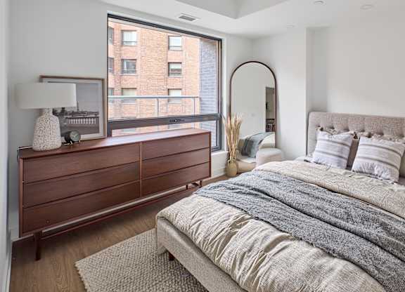 a bedroom with a bed and a large window