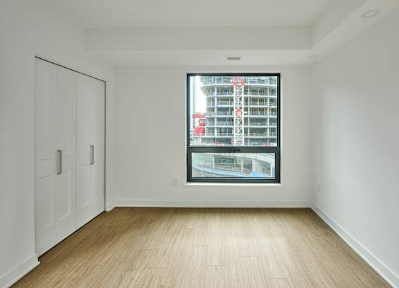 an empty room with a large window and white walls