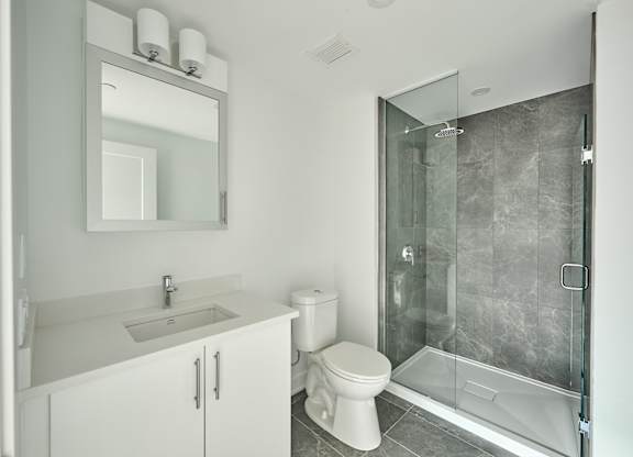 a white bathroom with a shower toilet and sink