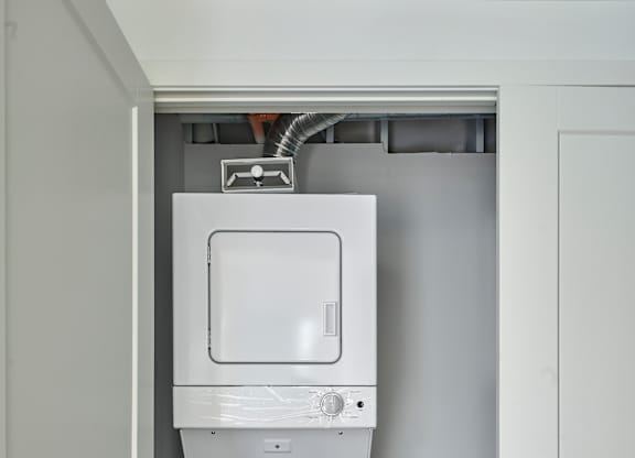 a white washer and dryer in a white closet