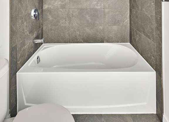 a bathroom with a white tub and a toilet