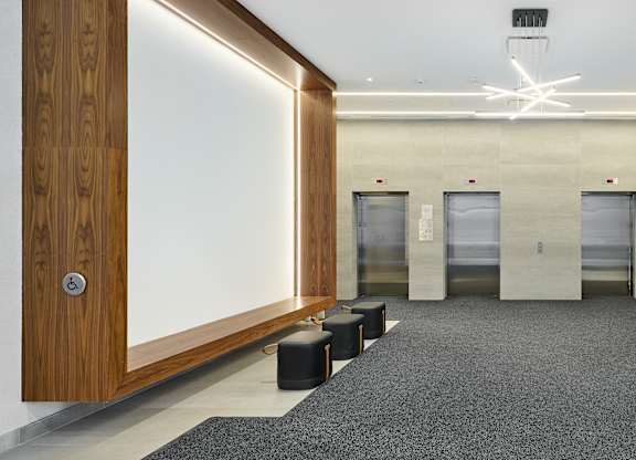 a lobby with four elevators and a white screen on the wall