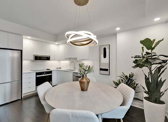 A modern kitchen with a dining table and chairs.