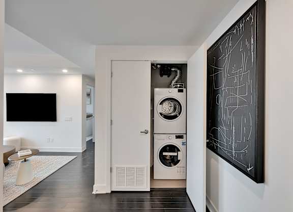 A modern laundry room with a washer and dryer built into the wall.