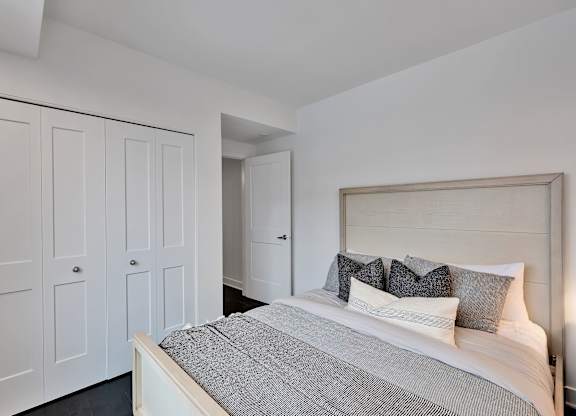 A bedroom with a bed, pillows, and a headboard.