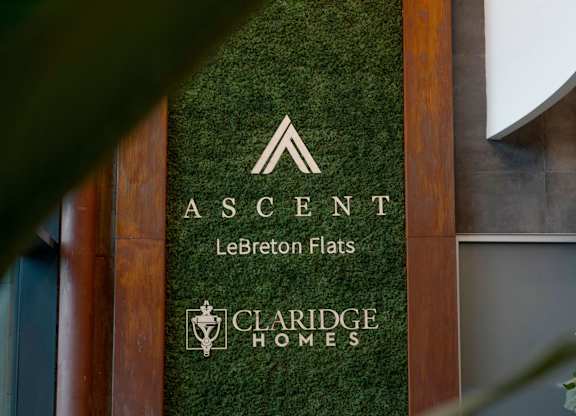 A green wall with a sign that says Ascent Le Breton Flats.