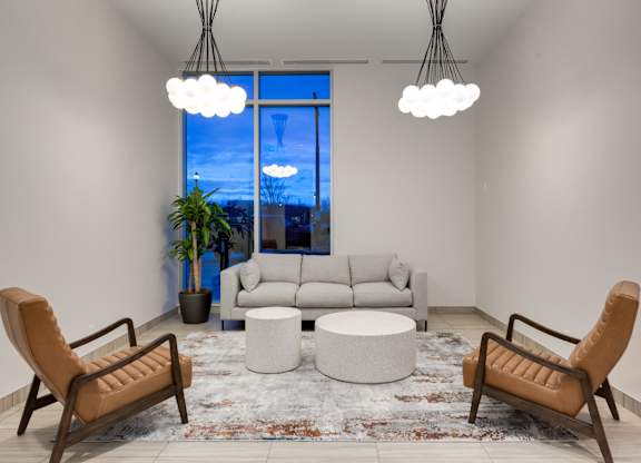 A living room with a large window, a sofa, a chair, a table, and a rug.