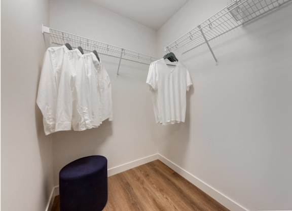 A row of white shirts hanging on a rack in a room.