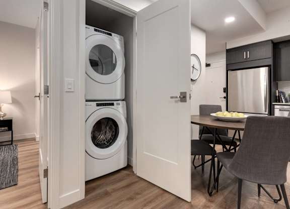 A modern laundry room with a washer and dryer built into the wall.
