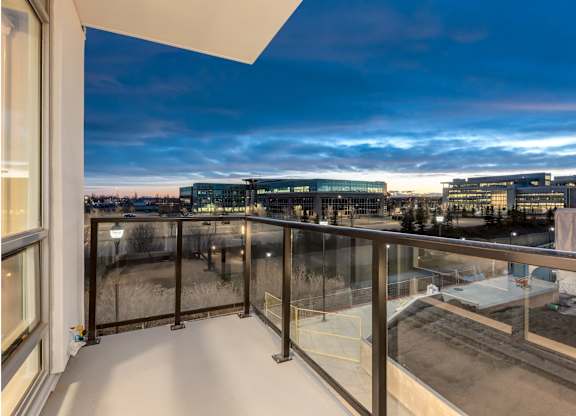 A balcony with a view of a cityscape at dusk.