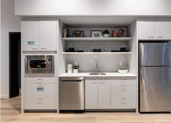 A modern kitchen with a refrigerator, oven, and sink.