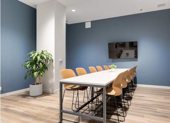 A conference room with a long table and chairs.