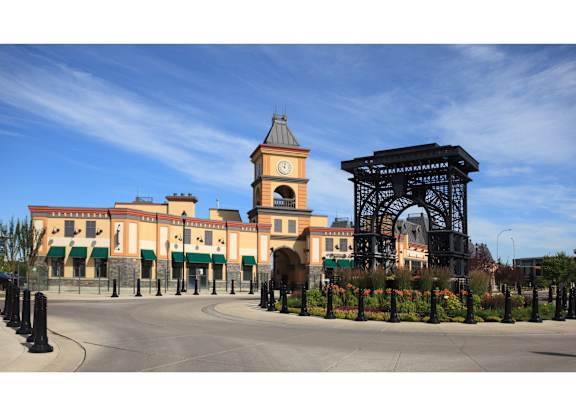 A large building with a clock tower and a large archway in front.