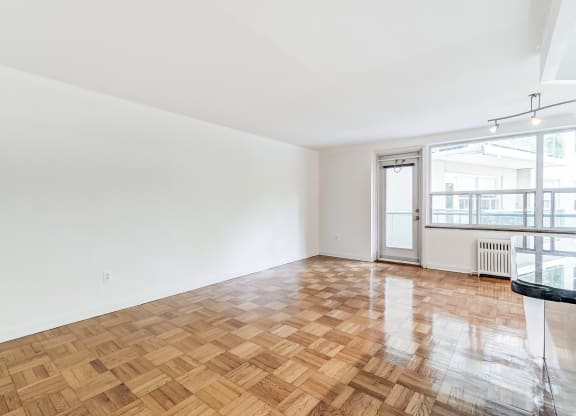 an empty living room with wood flooring and a balcony