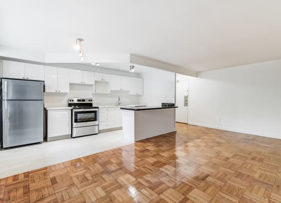 a renovated kitchen with white cabinets and stainless steel appliances