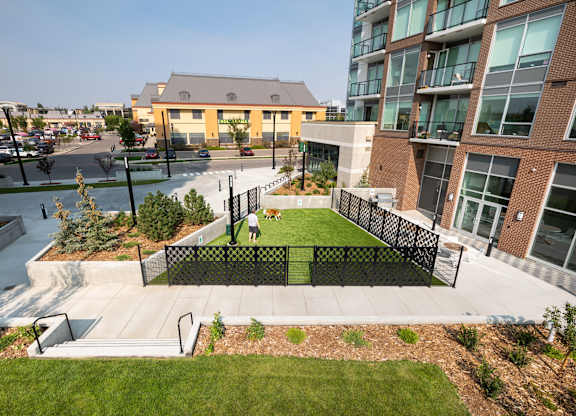 A modern building with a green space in front.
