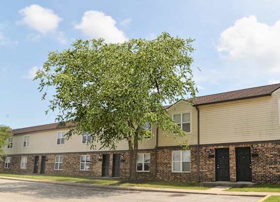 Apartment building with a tree in front of it.