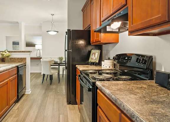 A kitchen with black appliances and wooden cabinets.