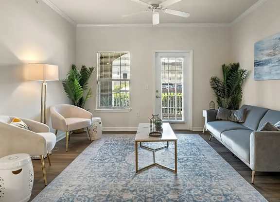 A living room with a grey couch, a coffee table, a chair, a floor lamp, and a painting on the wall.